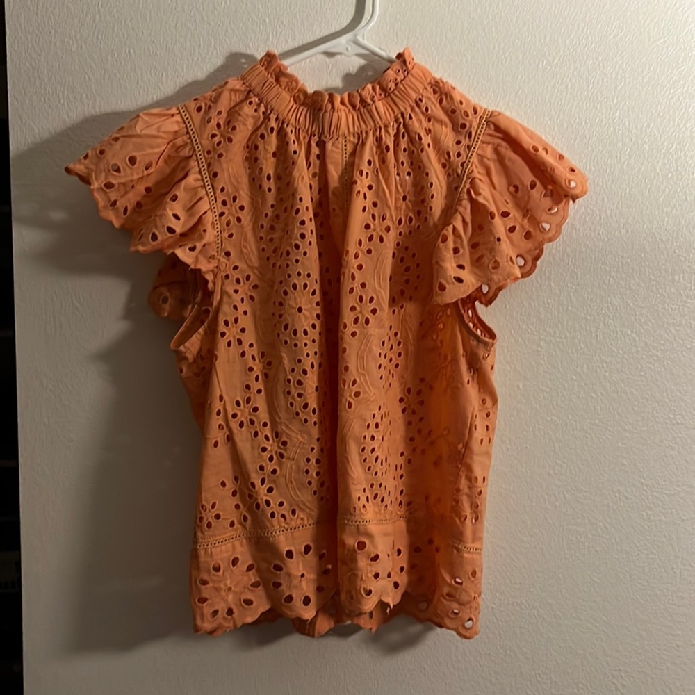 Coral cap sleeve shirt with cut outs.